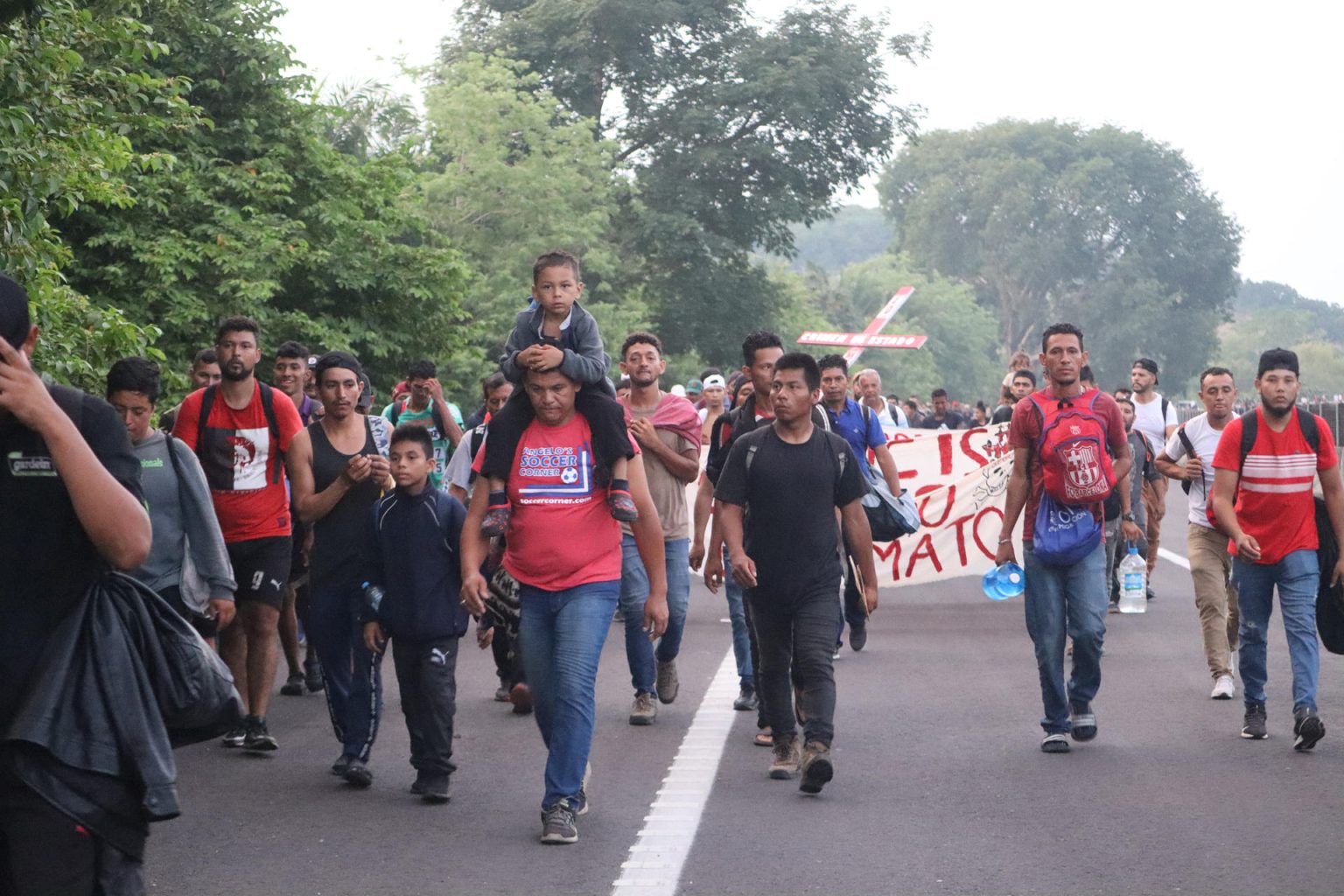 Migrantes caminan hoy en el "Viacrusis migrante" con rumbo a la Ciudad de México, en el municipio de Huixtla, en Chiapas (México). EFE/Juan Manuel Blanco