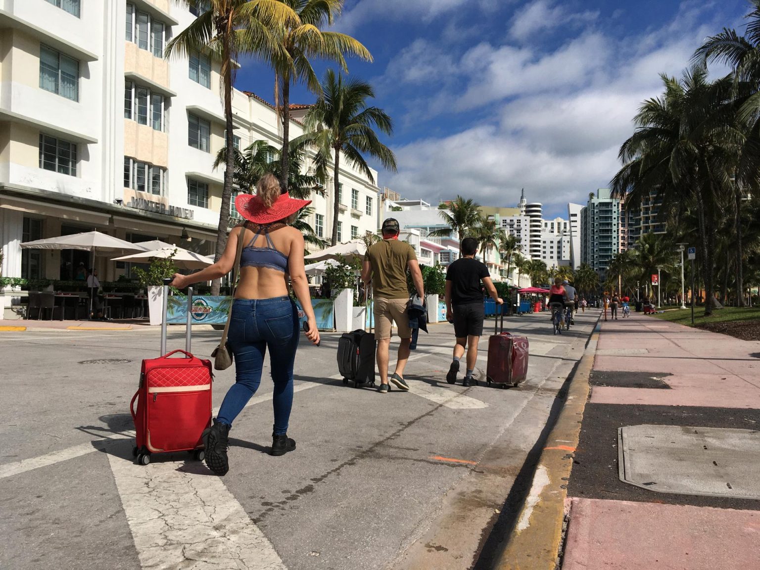 Varias personas caminan con su equipaje a través de la avenida Ocean Drive, en Miami Beach, Florida (Estados Unidos). Fotografía de archivo. EFE/Ivonne Malaver