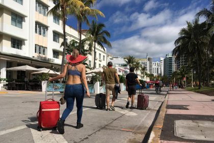 Varias personas caminan con su equipaje a través de la avenida Ocean Drive, en Miami Beach, Florida (Estados Unidos). Fotografía de archivo. EFE/Ivonne Malaver