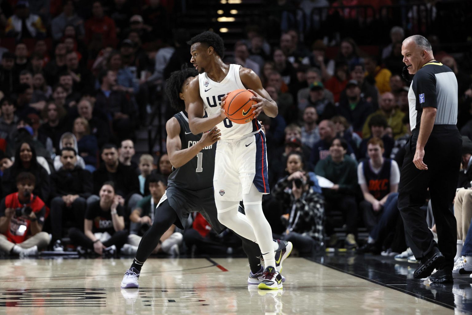 Bronny James (d), del Equipo USA, fue registrado este sábado, 8 de abril, al disputar un balón con Aden Holloway, del Equipo Resto del Mundo, durante un partido del Nike Hoop Summit 2023, en el coliseo Moda Center, en Portland (Oregon, EE.UU.). EFE/Soobum Im