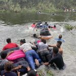 Un grupo de migrantes, ayudados de un inflable, intentan cruzar el Río Bravo hoy, en la ciudad de Matamoros en Tamaulipas (México). EFE/Abrahan Pineda-Jacome