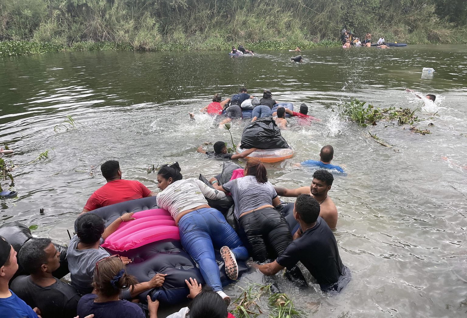 Un grupo de migrantes, ayudados de un inflable, intentan cruzar el Río Bravo hoy, en la ciudad de Matamoros en Tamaulipas (México). EFE/Abrahan Pineda-Jacome