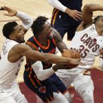 El alero de los Knicks, Julius Randle (c), comete una falta ofensiva entre el guardia de los Cavaliers, Donovan Mitchell (i), y el guardia de los Cavaliers, Isaac Okoro (d), durante la segunda mitad del juego 1 de los playoffs de la primera ronda de la Conferencia Este de la NBA entre los Cleveland Cavaliers y los New York Knicks, hoy, en el Rocket Mortgage Fieldhouse en la ciudad de Cleveland, Ohio (Estados Unidos). EFE/ David Maxwell