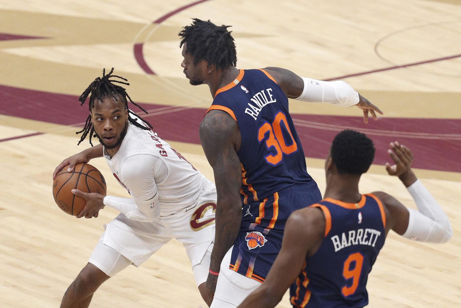 Darius Garland (i), guardia de los Cavaliers de Cleveland, fue registrado este martes, 18 de abril, al intentar superar la marca de Julius Randle y RJ Barrett, de los Knicks de Nueva York, durante el segundo partido de esta serie de 'playoff' de la Conferencia Este de la NBA, en el coliseo Rocket Mortgage FieldHouse, en Cleveland (Ohio, EE.UU.). EFE/David Maxwell