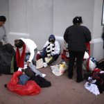 Inmigrantes indocumentados que recién cruzaron la frontera desde México buscan ropa de su talla en bolsas de ropa donada por voluntarios y organizaciones. Imagen de archivo. EFE/Jesús Rosales