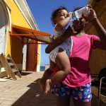 Fotografía de archivo de una mujer que le da agua a su bebé en San Juan, Puerto Rico. EFE/Thais Llorca