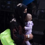 Varias personas evacuadas de Afganistán se disponen a subir a un autobús después de llegar al aeropuerto internacional Washington Dulles en Chantilly, Virginia, EE. UU. Fotografía de archivo. EFE/Michael Reynolds