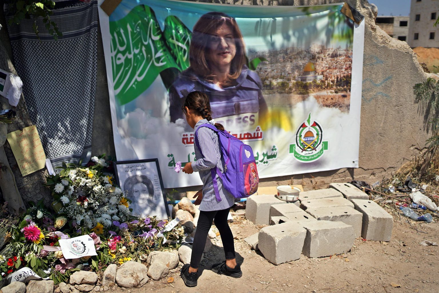 Una niña deja flores junto a un retrato de la periodista de Al Yazira Shireen Abu Akleh, en Yenín, Cisjordania. Fotografía de archivo. EFE/ Sara Gómez Armas