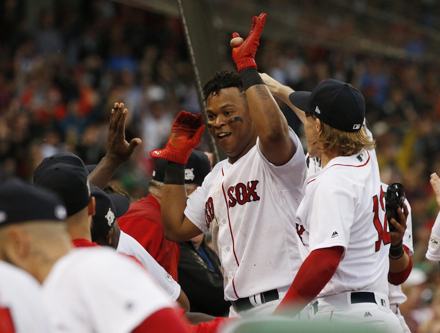 Fotografía de archivo en la que se registró al tercera base de los Medias Rojas, Rafael Devers (c), al celebrar un jonrón que anotó para la novena de Boston en la MLB. Devers aportó un vuelacercas y remolcó cuatro carreras en el triunfo de su equipo 11-5 sobre los Azulejos de Toronto. EFE/Rhona Wise