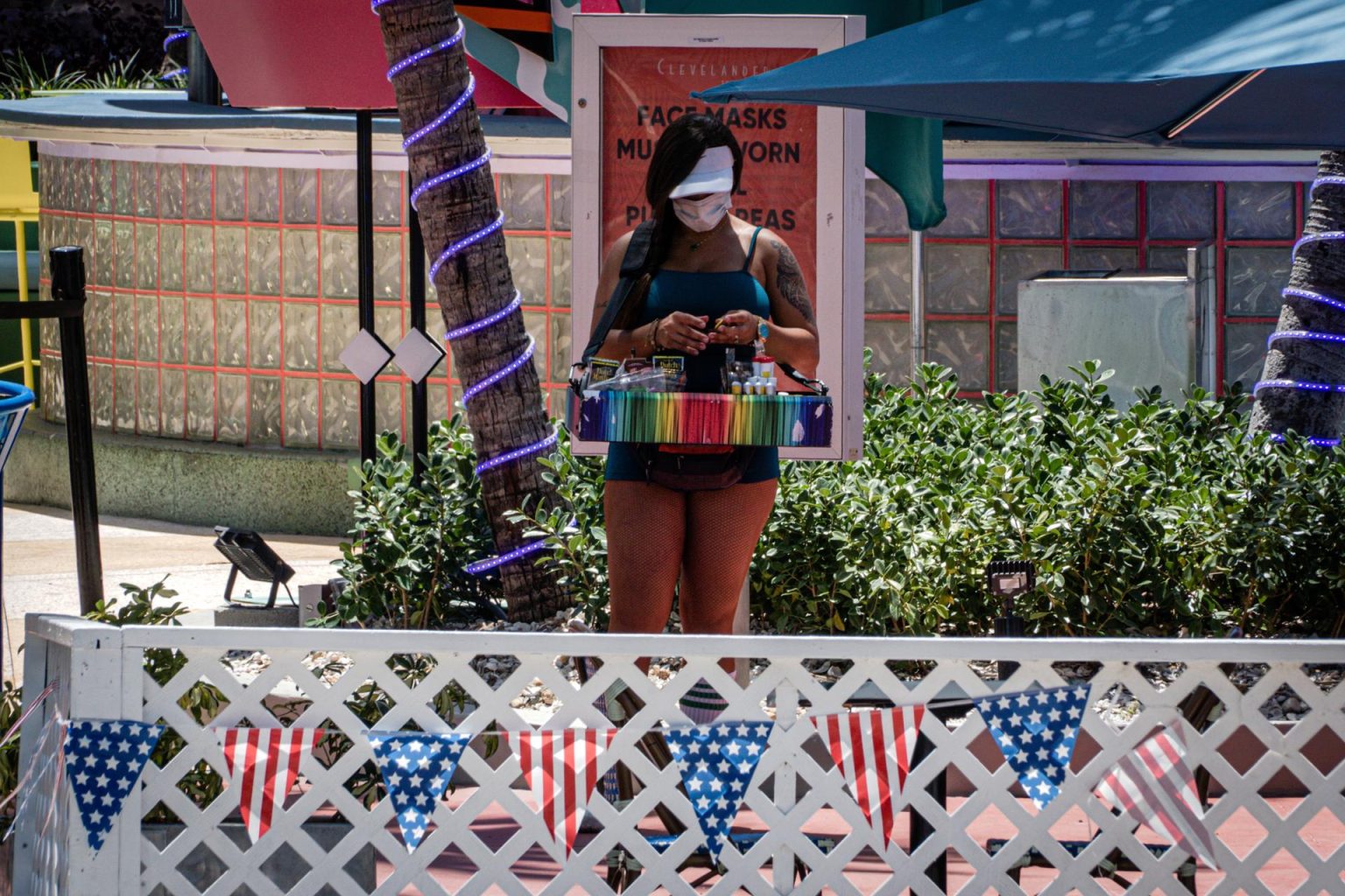 Una mujer usa tapabocas mientras vende tabaco y mecheros en el paseo turístico de Ocean Drive en Miami Beach, Florida. EFE/Giorgio Viera