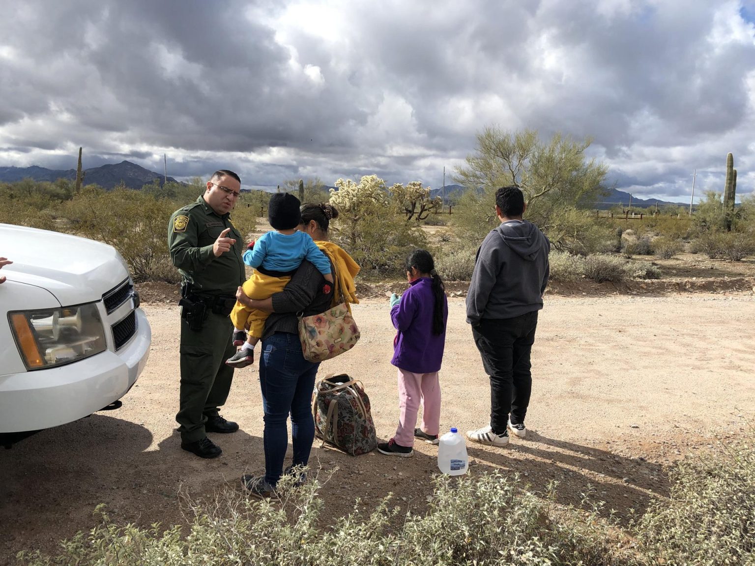 Fotografía de archivo donde aparece el portavoz de la Patrulla Fronteriza, Daniel Hernández, mientras habla con una inmigrante hondureña tras entregarse junto a sus tres en un punto del área conocido como Quitobaquito, en la frontera de Arizona con México (EE.UU.). EFE/Paula Díaz