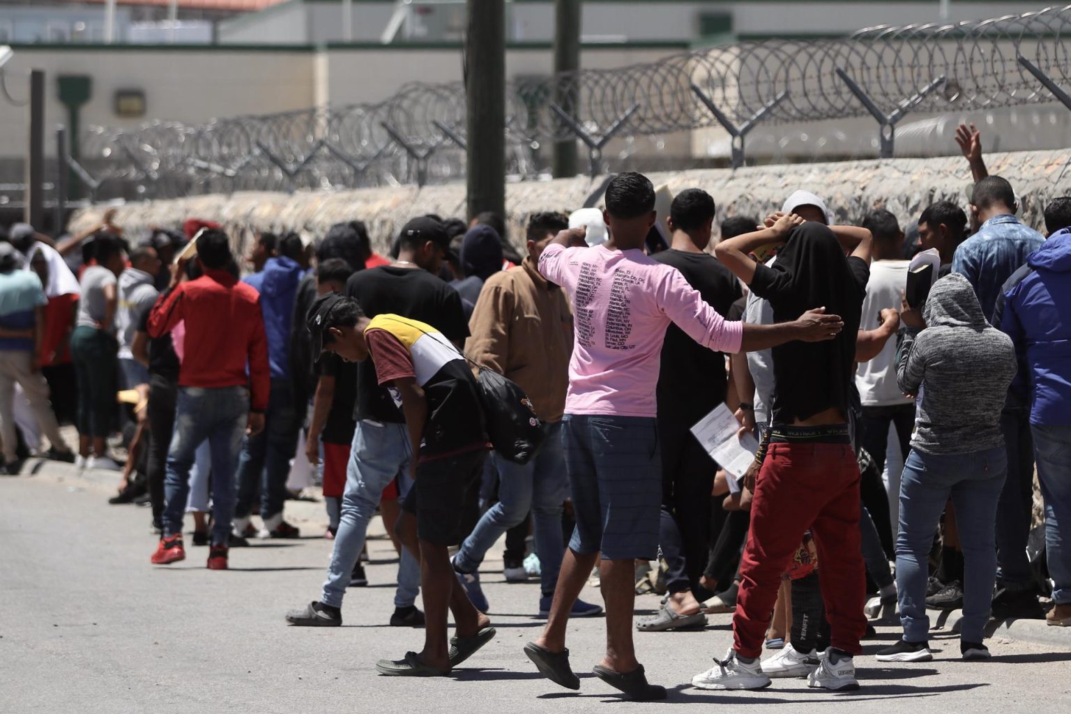 Migrantes hacen fila para entregarse voluntariamente a la Patrulla Fronteriza en la frontera de El Paso, Texas (EEUU). EFE/Jesús Rosales