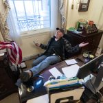 Un seguidor de Donald Trump se sienta en el escritorio de la portavoz de la Cámara de Representantes de Estados Unidos. Imagen de archivo. EFE/ JIM LO SCALZO