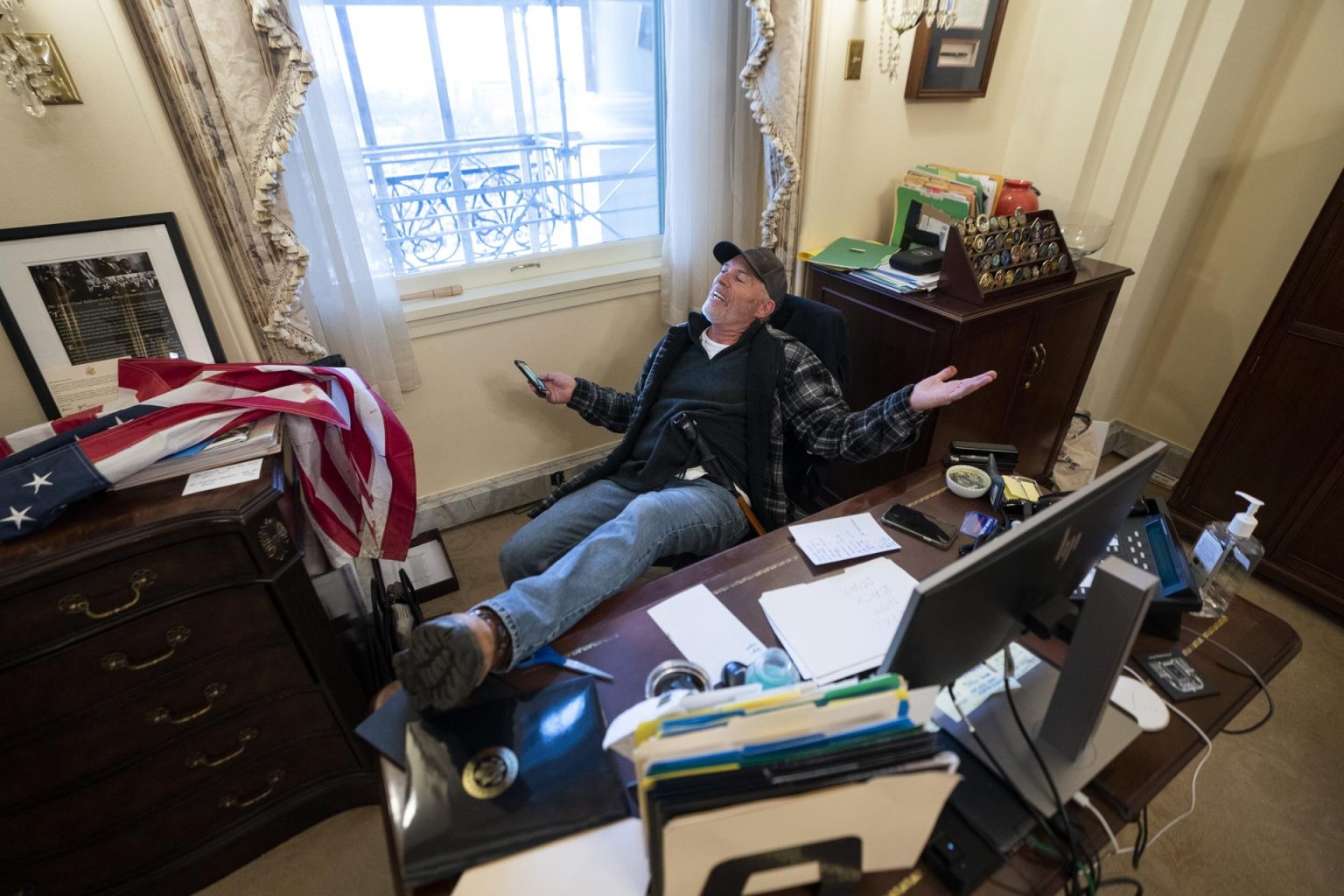 Un seguidor de Donald Trump se sienta en el escritorio de la portavoz de la Cámara de Representantes de Estados Unidos. Imagen de archivo. EFE/ JIM LO SCALZO