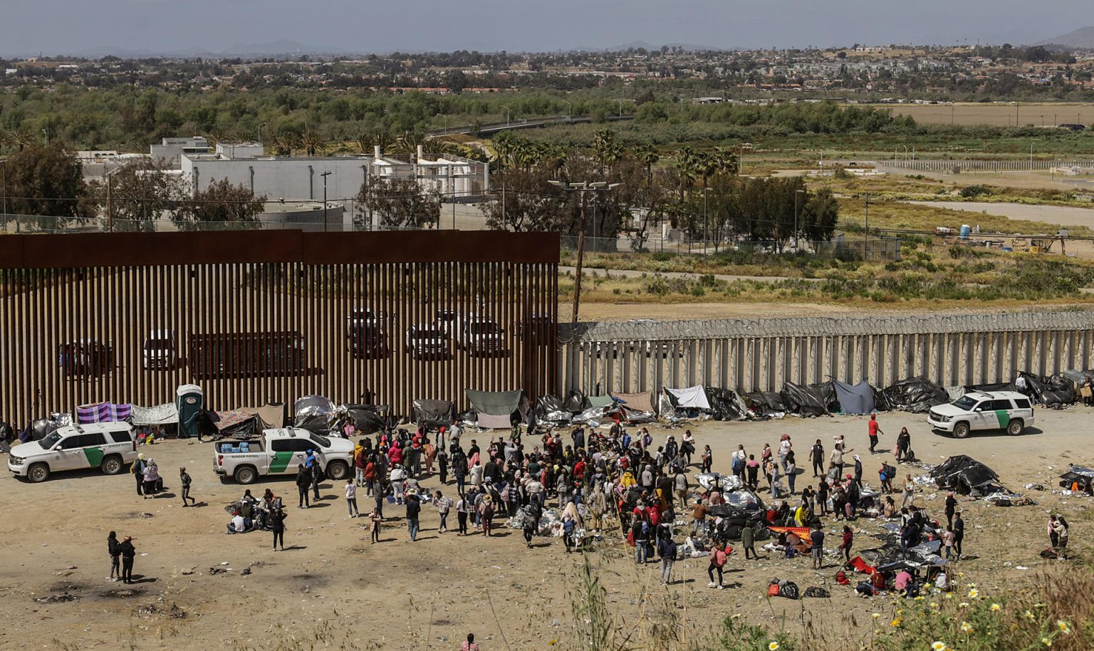 Fotografía general donde se observa a migrantes en un campamento junto al muro fronterizo, el 9 de mayo de 2023, en Tijuana, Baja California (México). EFE/Joebeth Terriquez