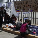 Migrantes escriben pancartas durante una manifestación para exigir justicia por 40 indocumentados que murieron por un incendio al exterior del Instituto Nacional de Migración (INM), en Ciudad Juárez (México).  EFE/Luis Torres.