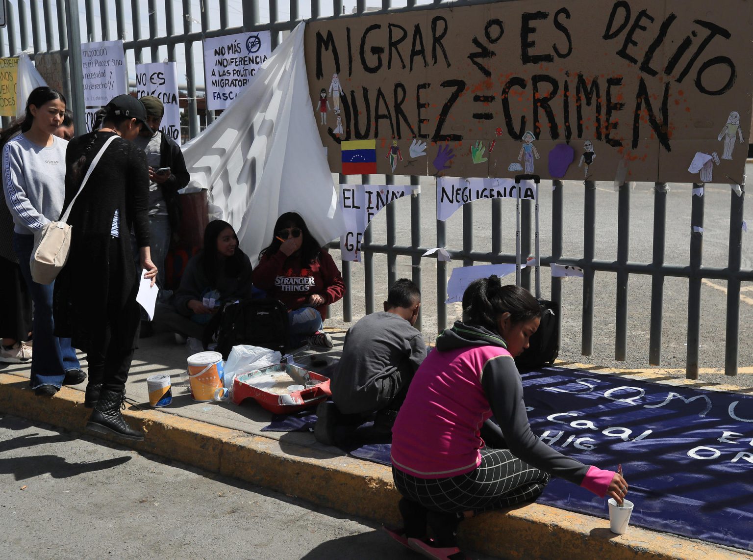 Migrantes escriben pancartas durante una manifestación para exigir justicia por 40 indocumentados que murieron por un incendio al exterior del Instituto Nacional de Migración (INM), en Ciudad Juárez (México).  EFE/Luis Torres.