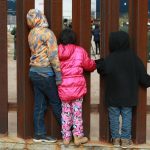 Un grupo de niños observan a agentes de migración de Estados Unidos. Imagen de archivo. EFE/David Peinado