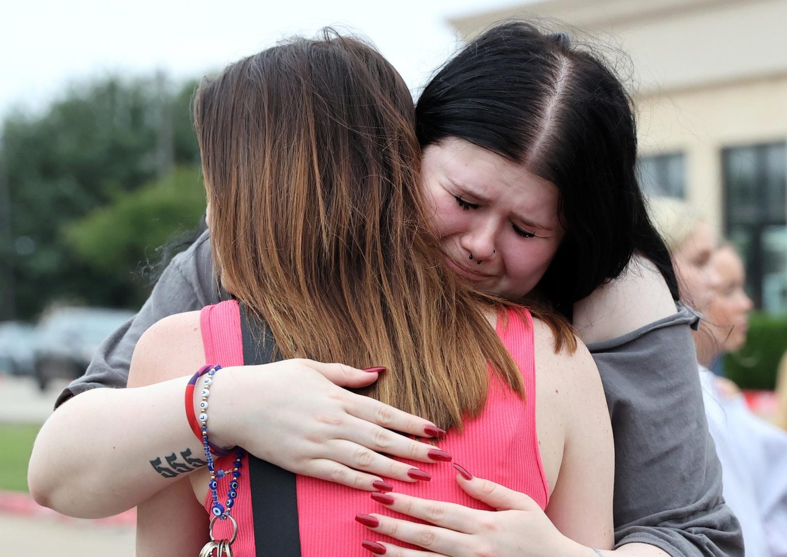 Alexa Keith (d) y Brooklyn Desse (i) se abrazan durante la vigilia en recuerdo del tiroteo que acabó con la vida de 9 personas en un centro comercial en Allen, Texas,Estados Unidos. EFE/ Adam Davis