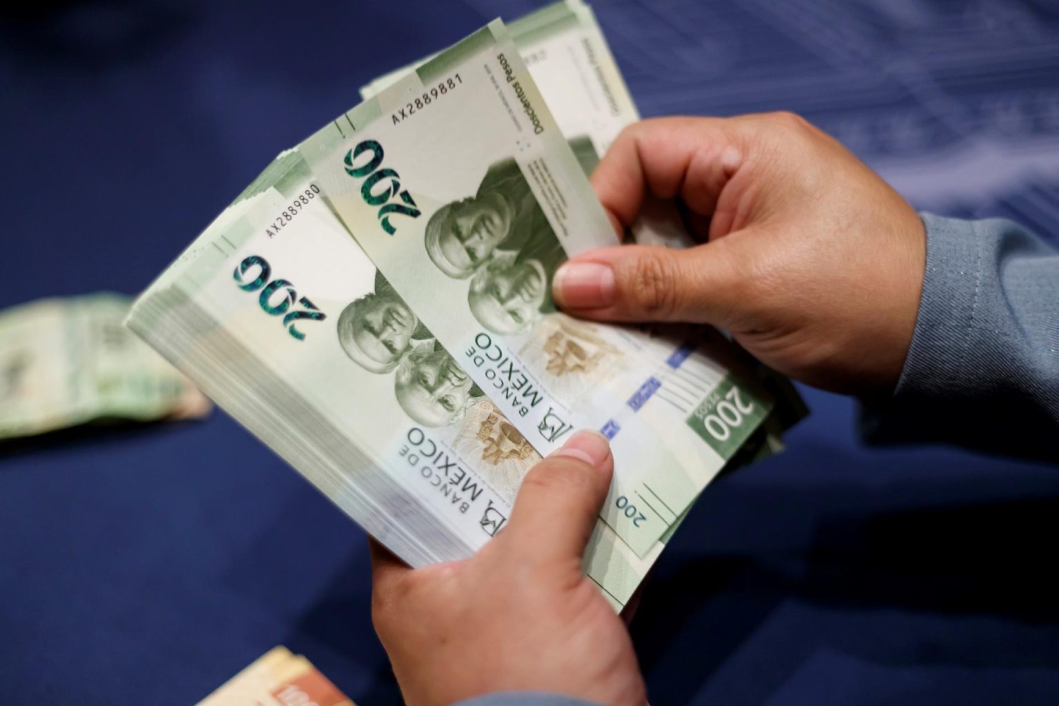 Fotografía de archivo de una mujer que muestra el billete de 200 pesos en Ciudad de México (México). EFE/ José Méndez