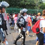 Policías vigilan a migrantes que hacen fila para conseguir documentación para transitar por el país en la ciudad de Tapachula en Chiapas (México). EFE/Juan Manuel Blanco