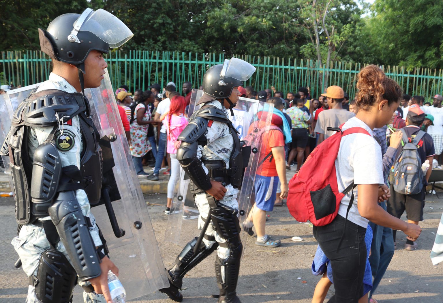 Policías vigilan a migrantes que hacen fila para conseguir documentación para transitar por el país en la ciudad de Tapachula en Chiapas (México). EFE/Juan Manuel Blanco