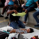 Fotografía de archivo donde aparece un migrante hondureño mientras trata de refrescar a su hijo después de varias horas caminando en carretera bajo el sol. Imagen de archivo. EFE/Esteban Biba