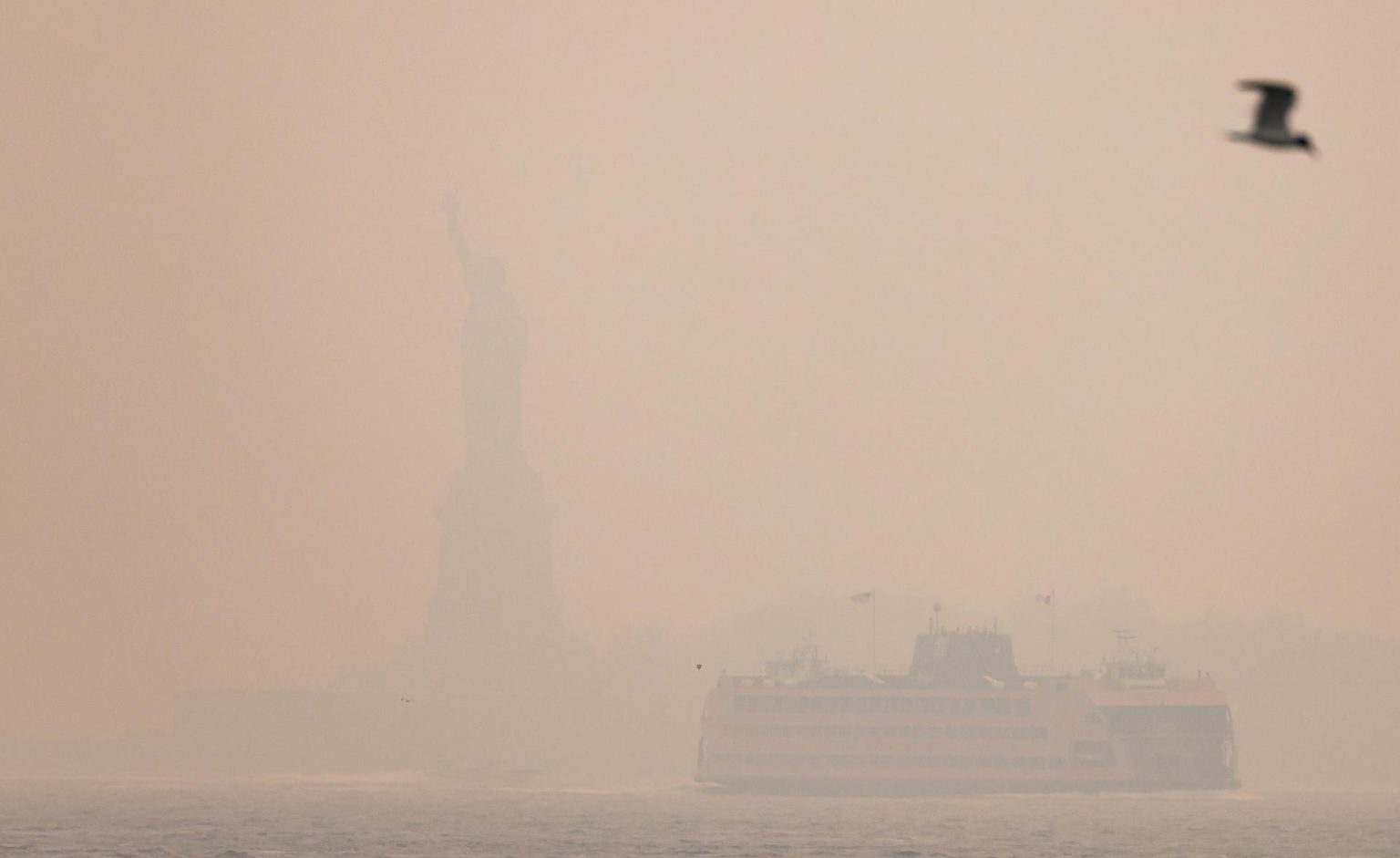 Registro general este miércoles, 7 de junio, de una silueta difusa de la Estatua de la Libertad, escondida bajo una capa de humo proveniente de los incendios forestales en Canadá, en State Island (NY, EE.UU.). EFE/Justin Lane