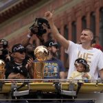 El pívot de los Denver Nuggets Nikola Jokic (d) encabeza el acto de celebración del título de la NBA, este 15 de junio de 2023, a bordo de un camión de bomberos junto al trofeo de campeones y el de MVP, en Denver Colorado (EE.UU.). EFE/Bob Pearson