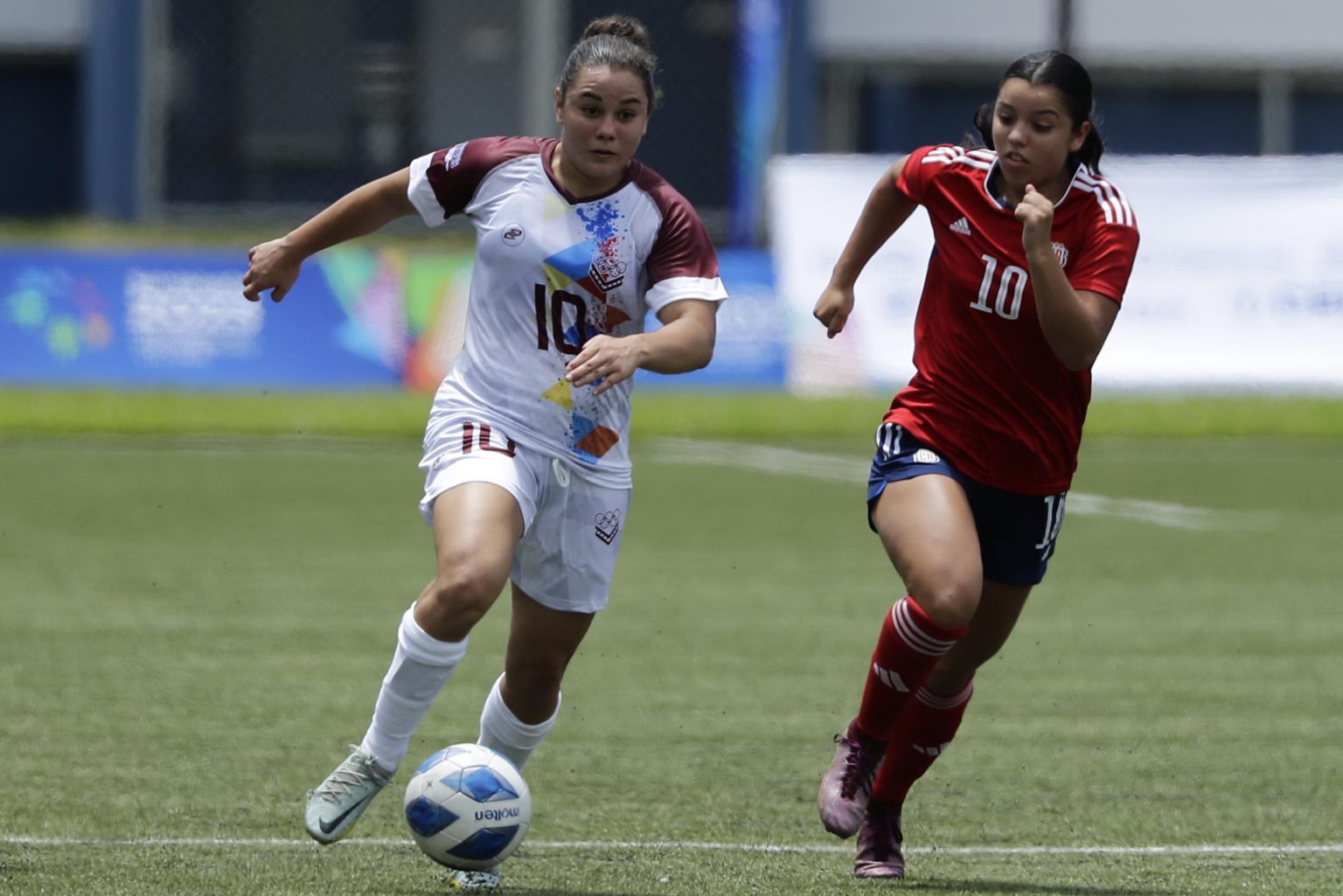 Amelie Araya (d), de Costa Rica, fue registrada este jueves, 29 de junio, al disputar un balón con Marianyela Jiménez, de Venezuela, durante un partido de la ronda preliminar de fútbol femenino de los Juegos Centroamericanos y del Caribe, en San Salvador (El Salvador). EFE/Rodrigo Sura