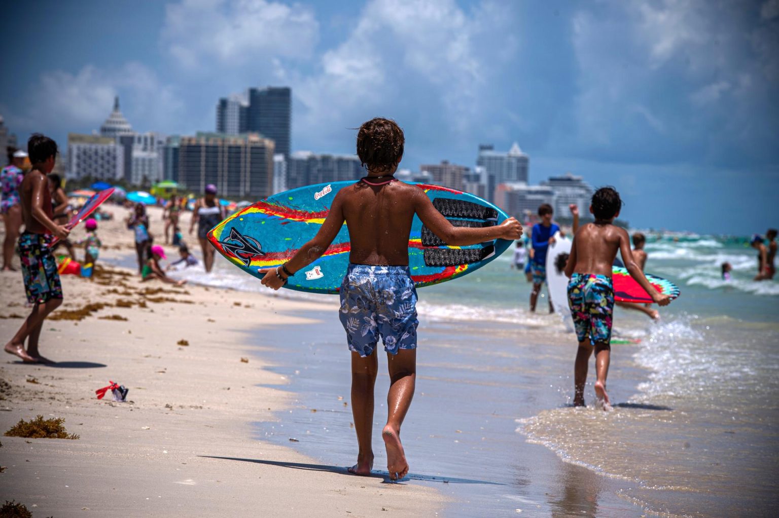 Un niño juega con una tabla de surf en una playa de Miami Beach, Florida. Fotografía de archivo. EFE/Giorgio Viera