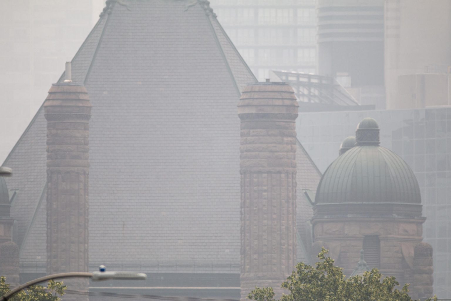 Fotografía de un edificio envuelto en humo de los incendios forestales de la provincia de Quebec, desde una calle en el centro de la ciudad de Toronto (Canadá). EFE/Julio César Rivas