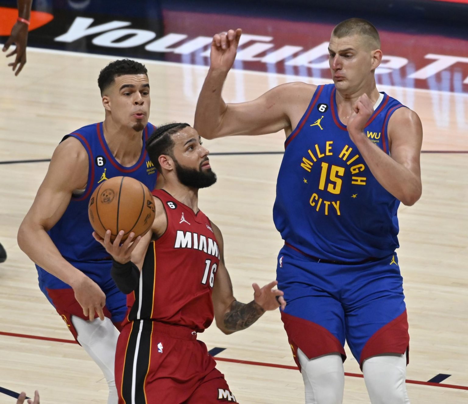 El jugador de los Miami Heat Caleb Martin (c) enfrenta la defensa del pívot de los Denver Nuggets Nikola Jokic (d), durante el primer juego de las finales de la NBA, el 1 de junio de 2023. EFE/Bob Pearson