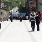 Personas se protegen del sol el 13 de junio de 2023, debido a las altas temperaturas registradas en el estado de Oaxaca (México). EFE/Jesús Méndez