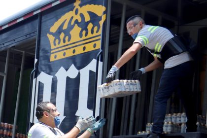 Unos trabajadores de la empresa mexicana Grupo Modelo trasladan paquetes de cervezas para su venta en tiendas de la Ciudad de México (México). Imagen de archivo. EFE/José Pazos