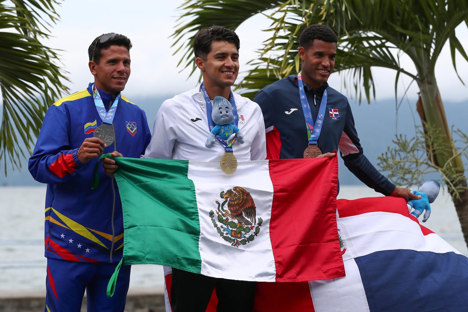 Alexis López (c) de México, medalla de oro, Andre Mora de Venezuela, medalla de plata, e Ignacio Vásquez de R.Dominicana, medalla de bronce, posan en el podio en la prueba scull individual de remo masculino durante los Juegos Centroamericanos y del Caribe en San Salvador (El Salvador). EFE/ José Jácome