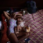 Una migrante venezolana junto a su hijo descansan en un albergue temporal tras cruzar la selva del Darién rumbo a los Estados Unidos en Los Planes de Gualaca (Panamá). EFE/Bienvenido Velasco