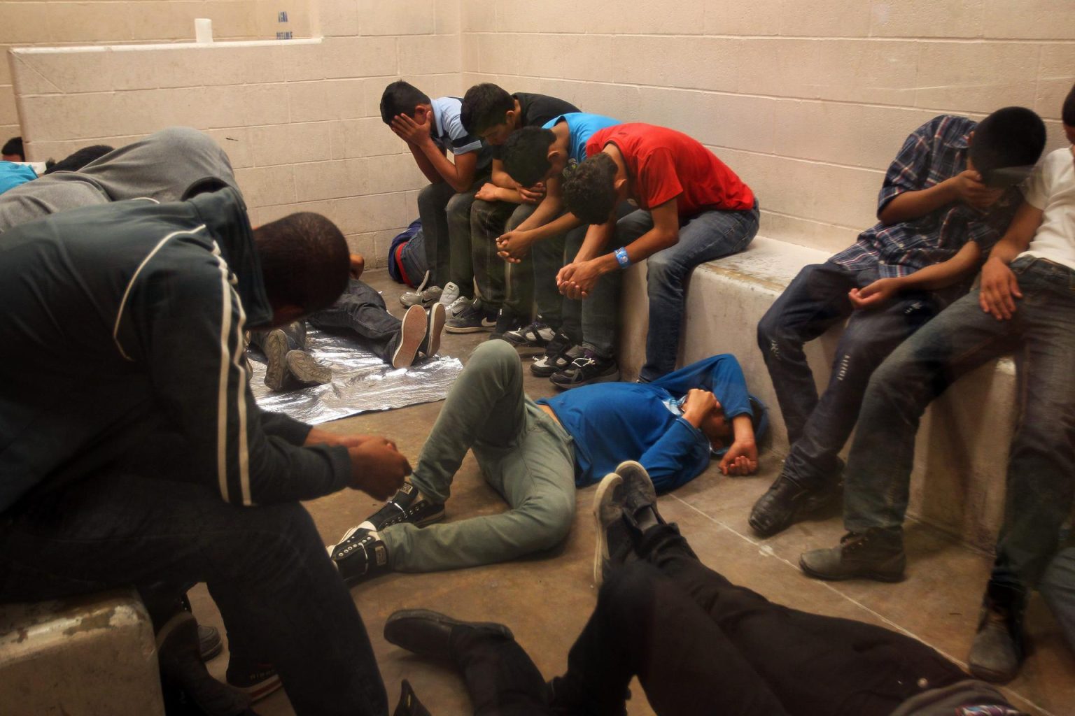 Fotografía de archivo donde se observan varios inmigrantes que han cruzado ilegalmente la frontera, detenidos para ser procesados dentro de una estación de la Patrulla Fronteriza. EFE/Rick Loomis / POOL