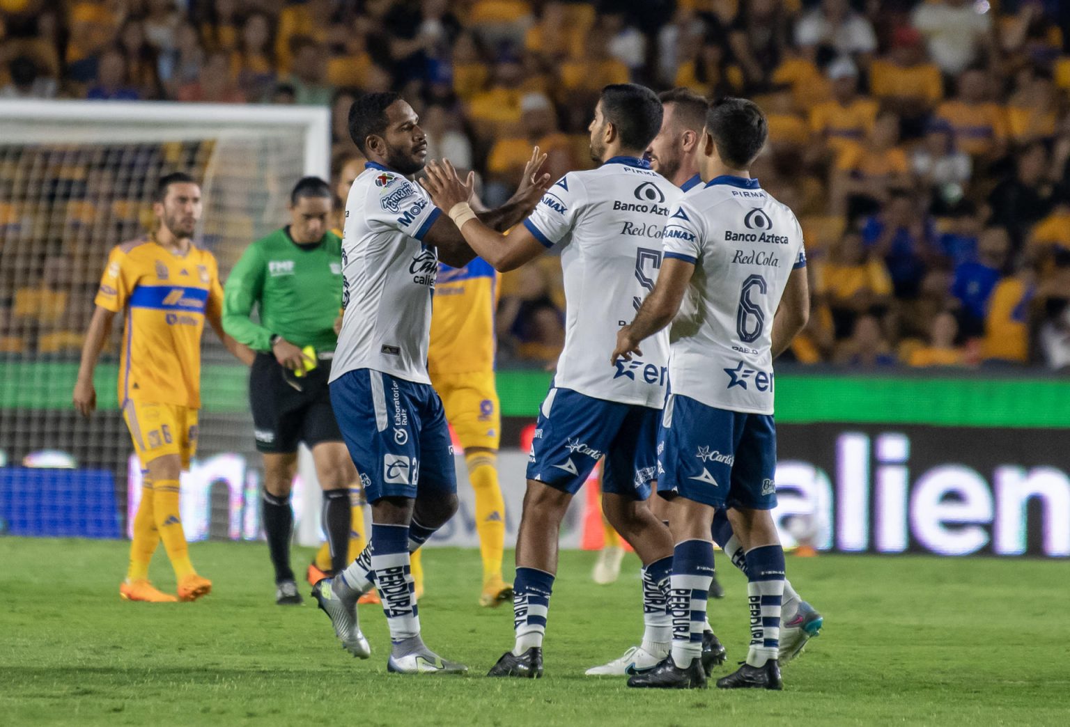 Brayan Angulo (c-i), del Puebla, fue registrado este sábado, 1 de julio, al celebrar, con varios compañeros, un gol que le anotó a Tigres, durante un partido de la jornada 1 del Torneo Apertura 2023 del fútbol en México, en el estadio Universitario, en Monterrey (México). EFE/Miguel Sierra