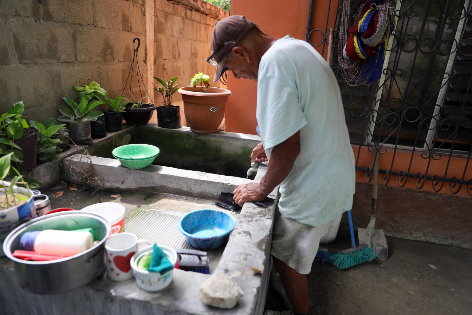 Un hombre abre una válvula para recibir agua en un barrio del municipio de Choloma, beneficiado con proyectos comunitarios para el acceso a agua potable, al norte de Honduras. EFE/Gustavo Amador