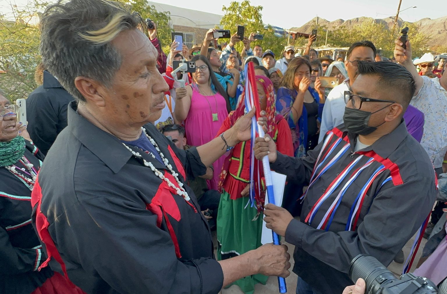 El gobernador tradicional, Genaro Gabriel Robles Blanco (d), recibe el bastón de mando por el presidente del Consejo de Ancianos, Enrique Robles (i), durante la celebración del Año nuevo Seri, en el municipio de Hermosillo, en Sonora (México). EFE/Daniel Sánchez