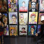 Los artistas Sara Velázquez (i) y Raúl Kaluriz (d) posan junto a sus obras de la exposición "100 Fridas para Frida", durante la inauguración de la exhibición hoy, en Ciudad de México (México). EFE/Mario Guzmán