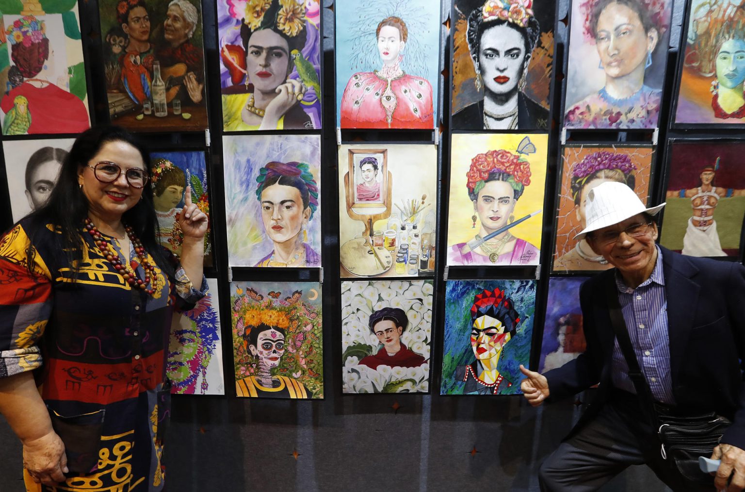 Los artistas Sara Velázquez (i) y Raúl Kaluriz (d) posan junto a sus obras de la exposición "100 Fridas para Frida", durante la inauguración de la exhibición hoy, en Ciudad de México (México). EFE/Mario Guzmán