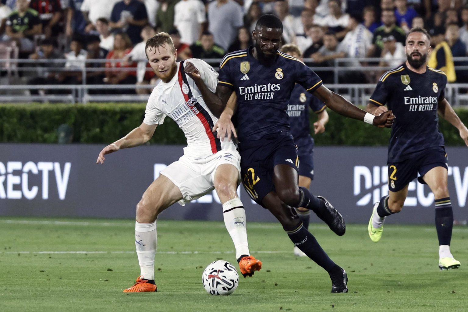 El centrocampista del Milan AC Tommaso Pobega (i) en acción contra el defensor del Real Madrid Antonio Rudiger (d) durante la segunda mitad del partido amistoso de fútbol entre el Real Madrid y el AC Milan. EFE/EPA/ETIENNE LAURENT