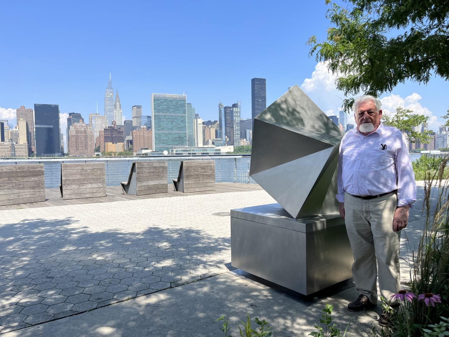 El artista español Manuel Ferreiro Badía posa durante una entrevista con EFE junto a su escultura titulada "Compostela, a Fractal Study of a shell" hoy en el Hunters Point South Park en Queens, Nueva York. EFE/Nora Quintanilla