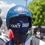 Fotografía de archivo de un fotógrafo haitiano llevando una mascarilla con la frase "I can't breathe" (no puedo respirar) mientras cubre una protesta en Puerto Príncipe (Haití). EFE/ Jean Marc Hervé Abelard