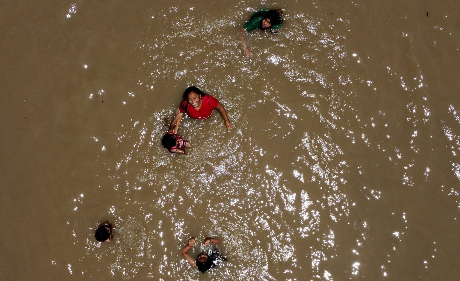 Personas se bañan en el agua del río Bravo, hoy, en Ciudad Juárez (México). EFE/ Luis Torres