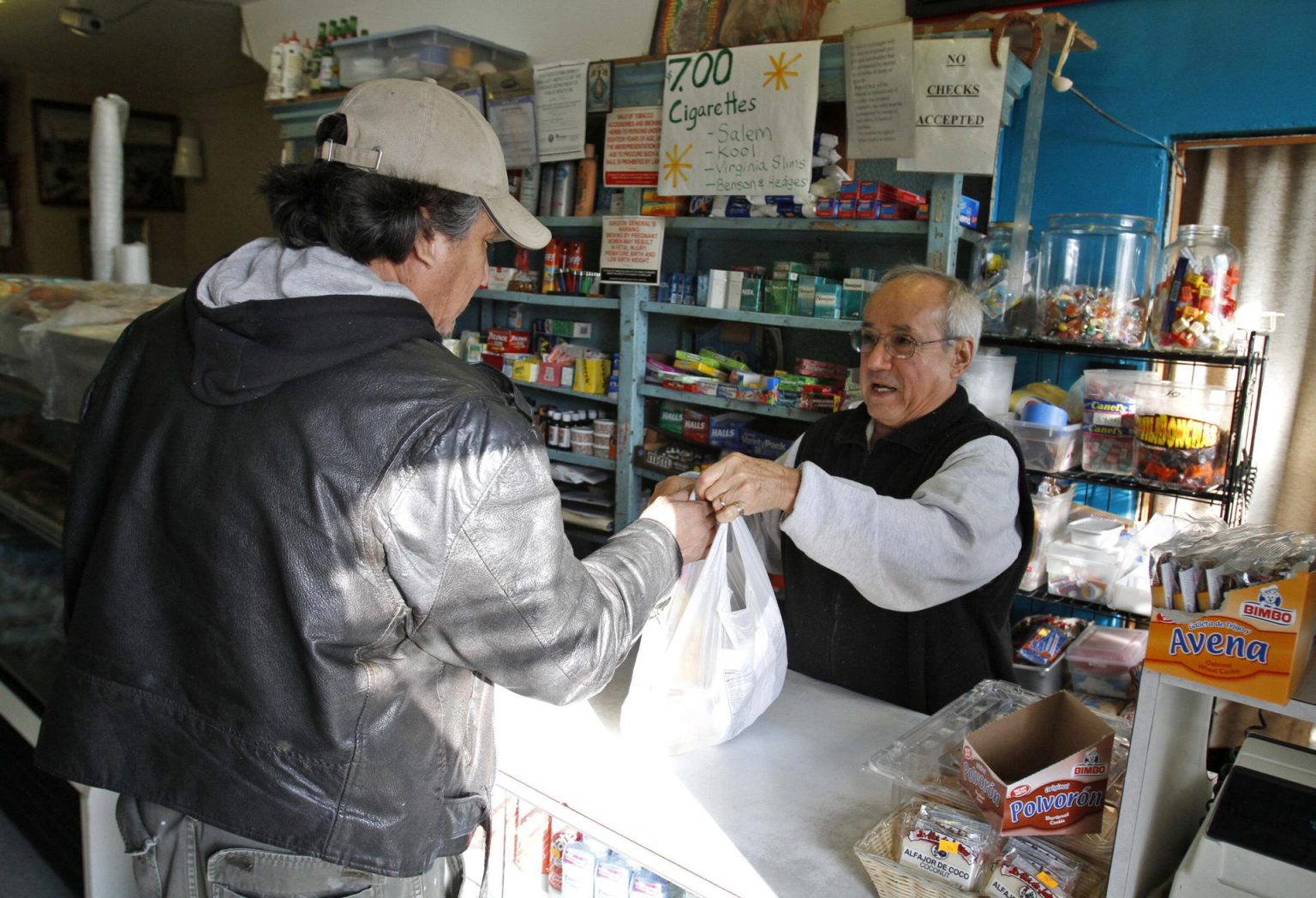 Fotografía de archivo de un tendero que ayuda a un cliente en su tienda. EFE/Kamil Krzaczynski