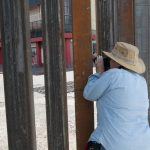 Fotografía de archivo de una persona que mira al otro lado del muro fronterizo en Arizona. EFE/Gary Williams