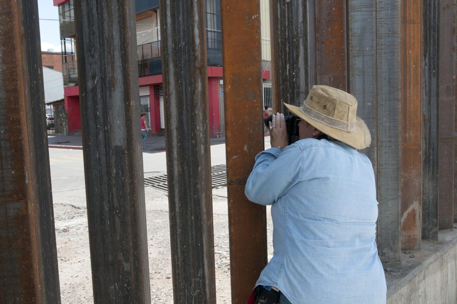 Fotografía de archivo de una persona que mira al otro lado del muro fronterizo en Arizona. EFE/Gary Williams